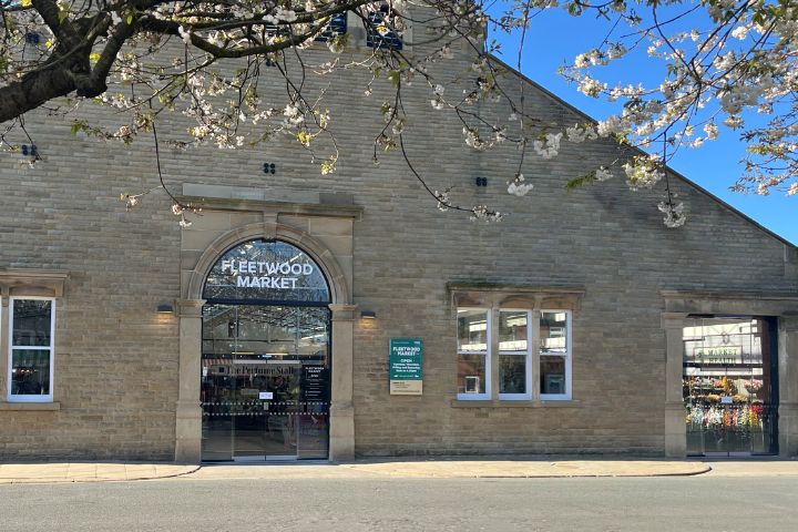 Entrance to Fleetwood market with a blue sky and blossom tree.